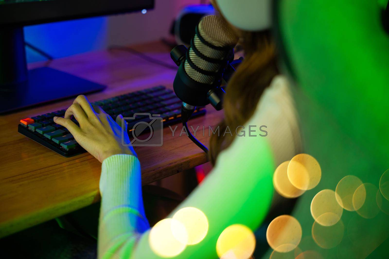 Royalty free image of gamer woman press on keyboard to playing video games online on computer she live stream and chat with fans by Sorapop