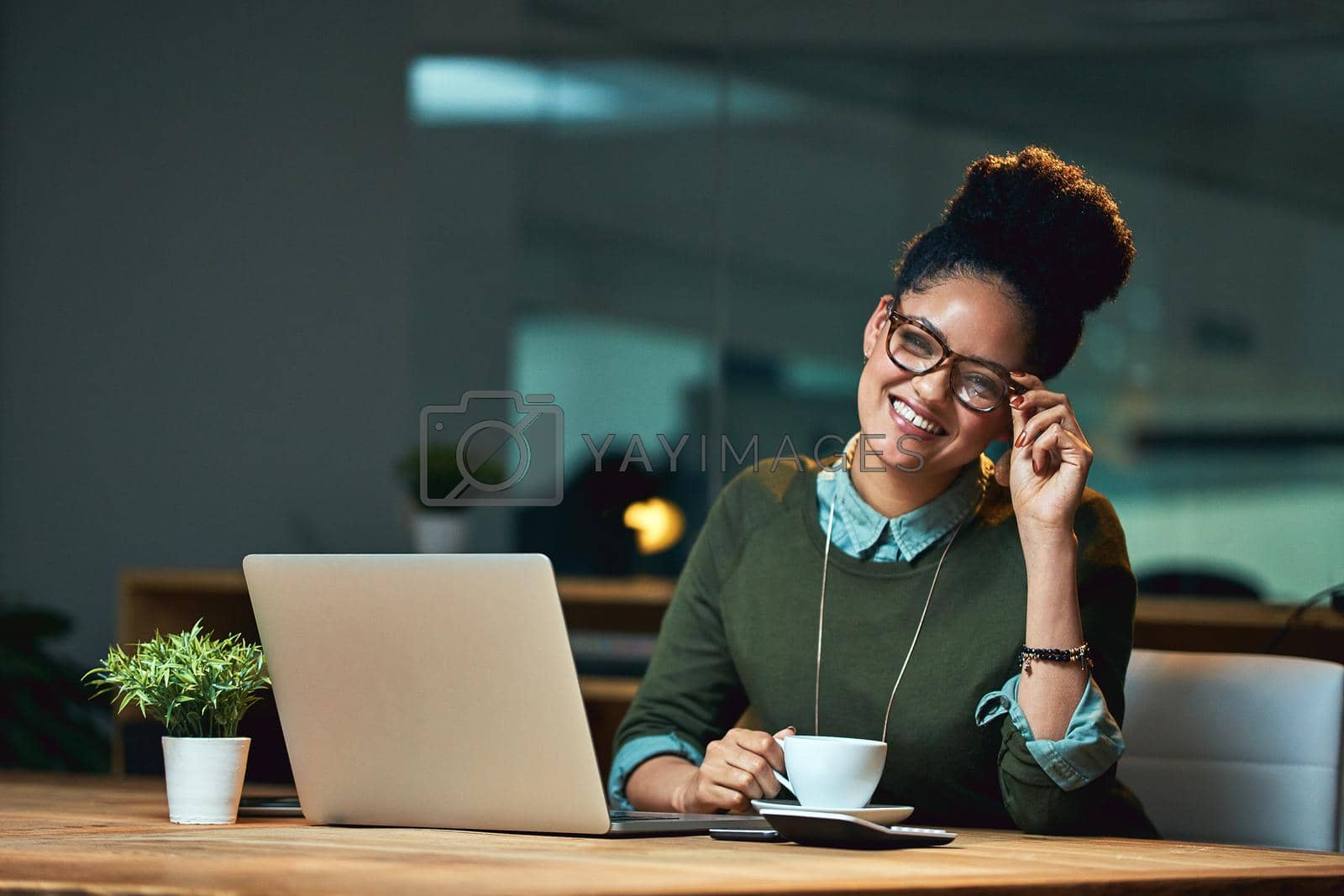 Royalty free image of Enjoying the quiet that overtime brings. Portrait of an attractive young woman working on her laptop in the office. by YuriArcurs