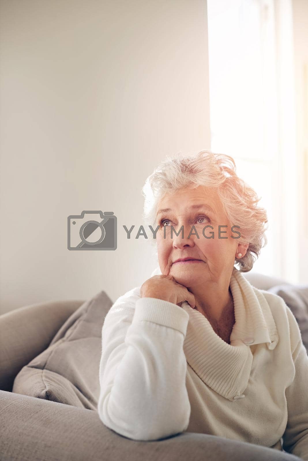 Royalty free image of Journeying through memory lane. a senior woman looking thoughtful at home. by YuriArcurs
