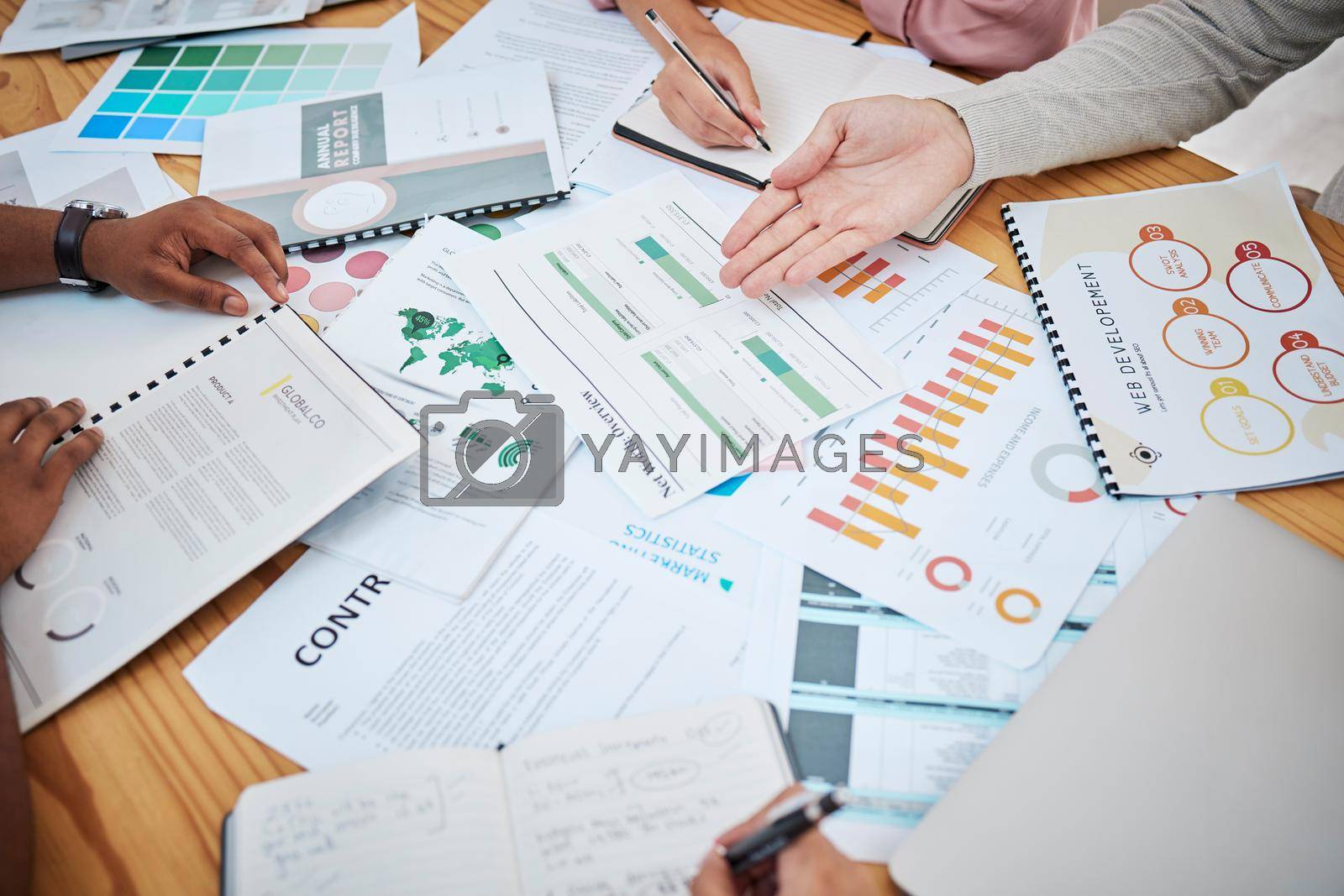 Royalty free image of Above table with finance papers, graphs and big data during teamwork meeting with accounting or marketing team discussing budget, strategy or growth development. Closeup of SEO team doing research by YuriArcurs