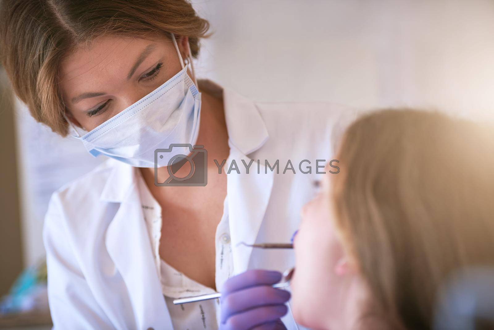 Dental service with a gentle touch. a dentist examining a little girls teeth