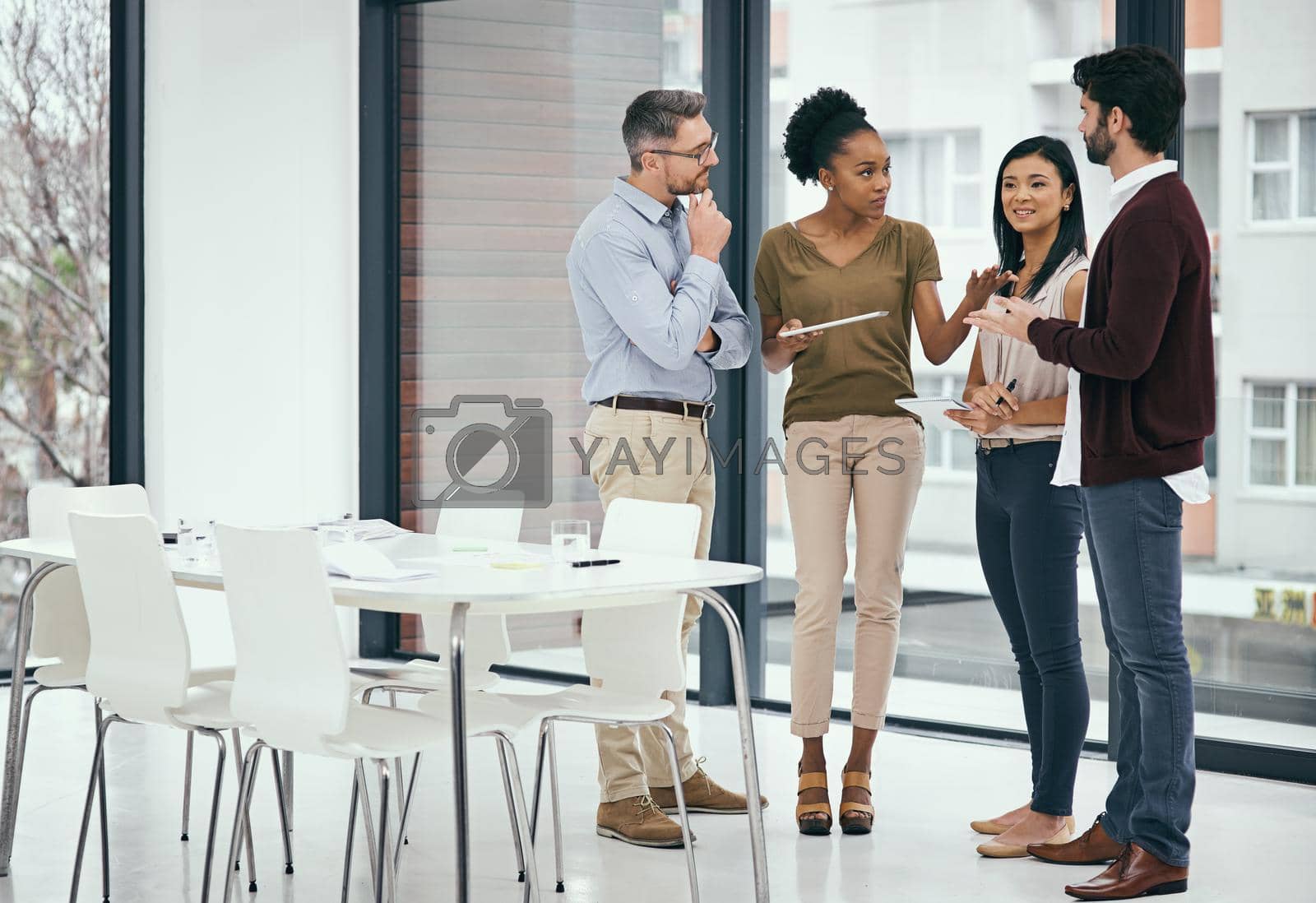 Royalty free image of Letting ambition drive them towards success. a group of colleagues having a discussion in an office. by YuriArcurs