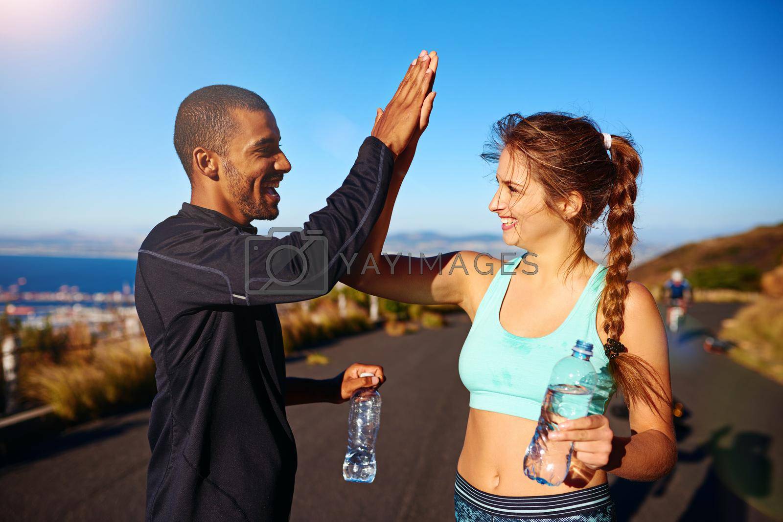 Royalty free image of Healthy habits can leave you feeling so amazing. a sporty young couple high fiving each other outside. by YuriArcurs