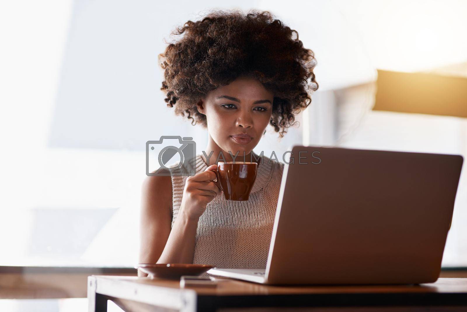 Royalty free image of Start small and build on your success. a young business owner using a laptop while sitting in her cafe. by YuriArcurs