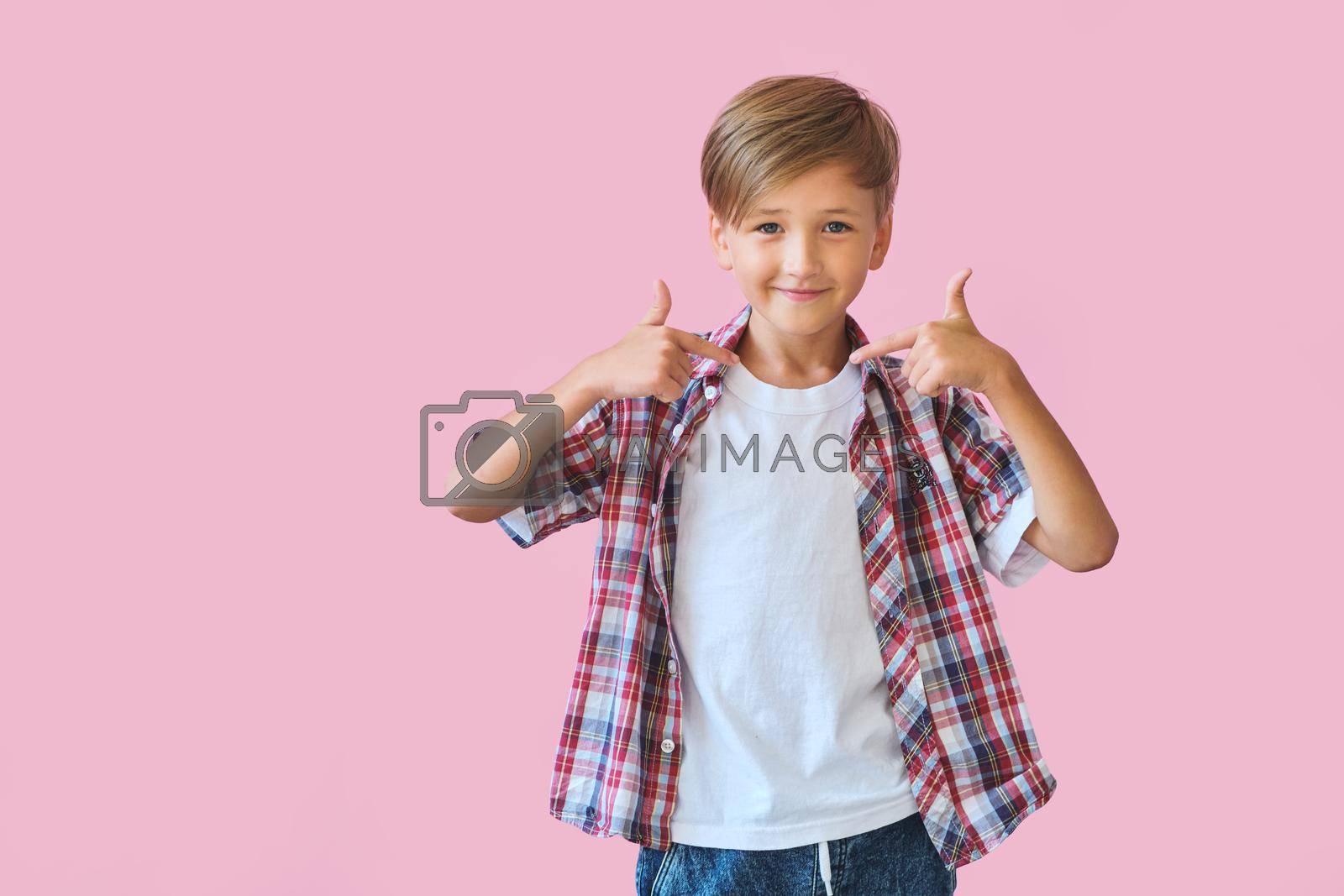 Royalty free image of Young happy teen boy with in casuals on pink background. by InnaVlasova