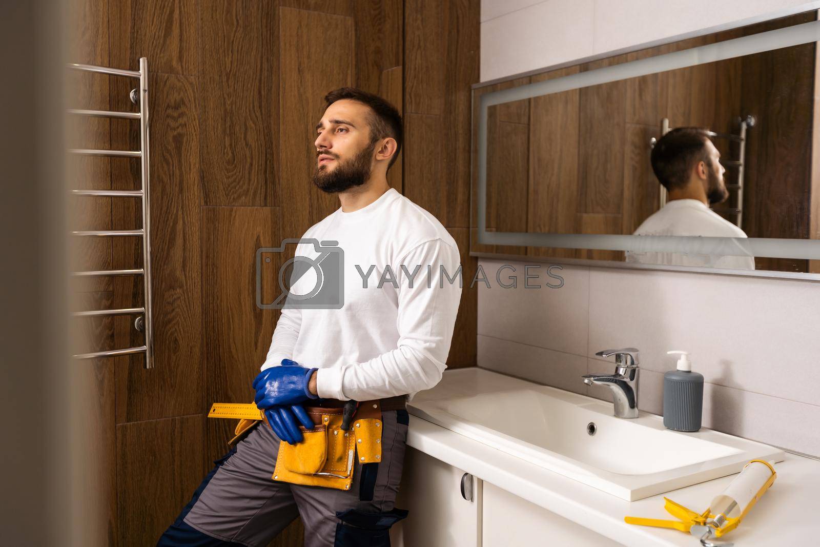 Royalty free image of Professional plumber with plunger and instruments near sink. by Andelov13