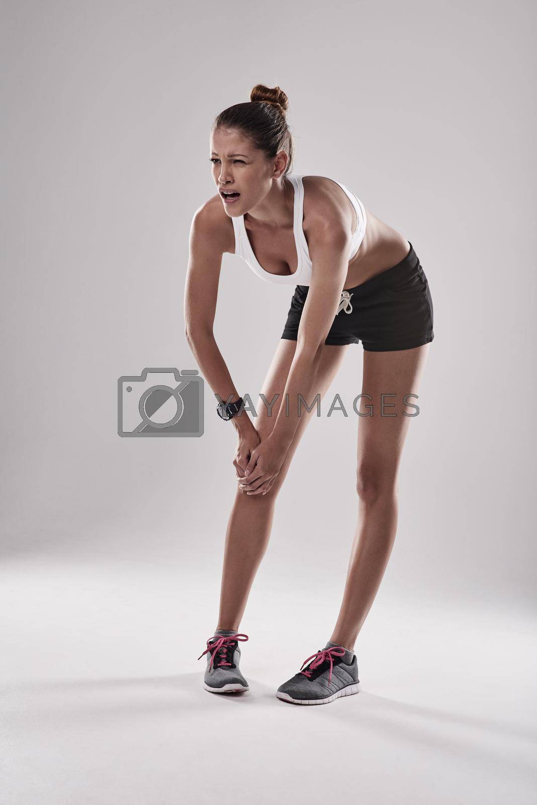 Royalty free image of Pain is acceptable, injury is acceptable but quitting is unacceptable. Studio shot of an athlete with an injury. by YuriArcurs