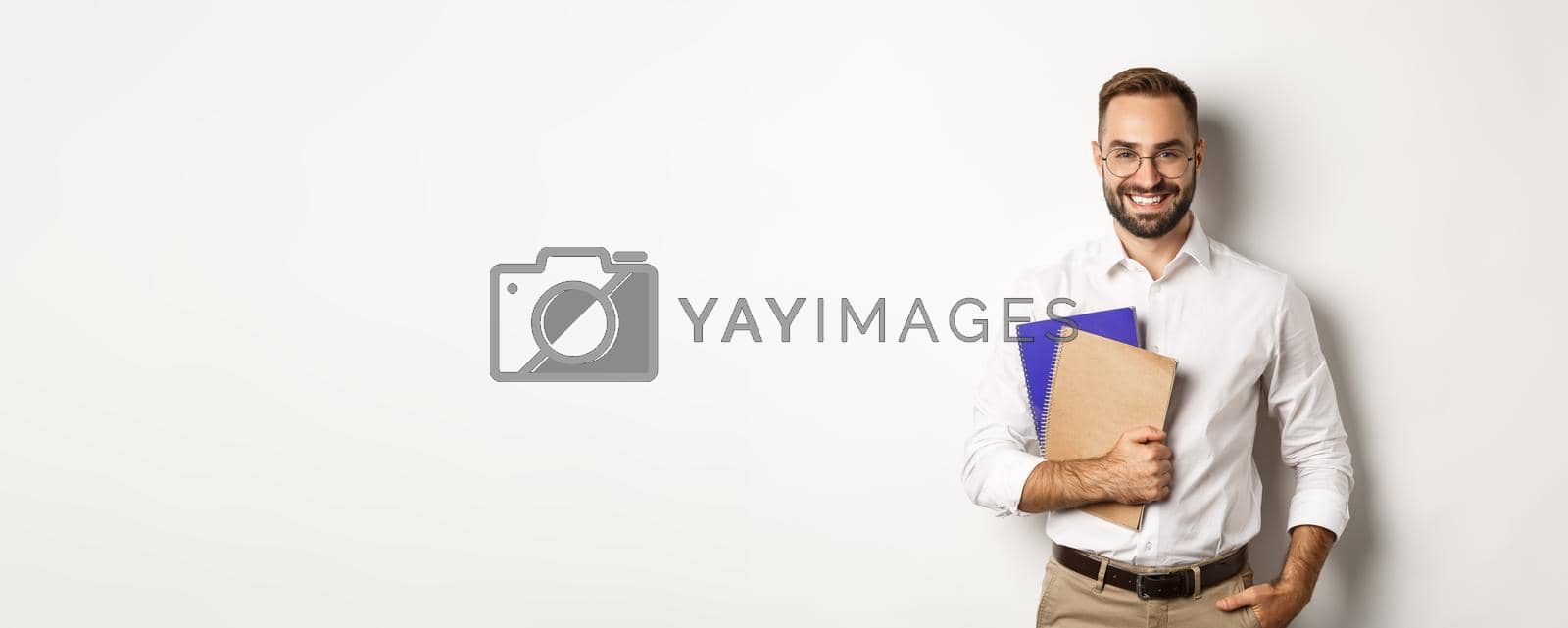 Royalty free image of Young handsome man holding notebooks, concept of e-learning and courses by Benzoix