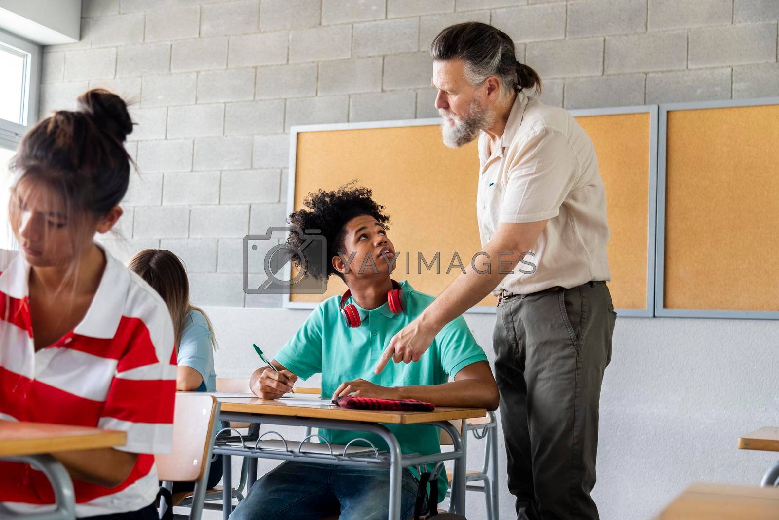 Royalty free image of African american teen boy high school student ask for help with homework to adult mature caucasian male teacher. by Hoverstock