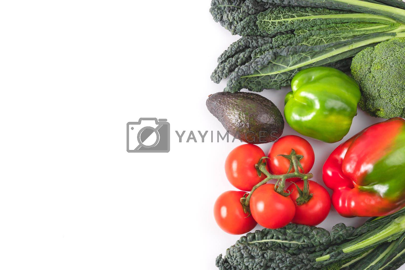 Royalty free image of Fresh vegetables frame. Black kale leaves, tomatoes branch, red and green bell pepper, avocado. Delicious raw vegetable food mockup. Concept of healthy food. Top view, flat lay by photolime
