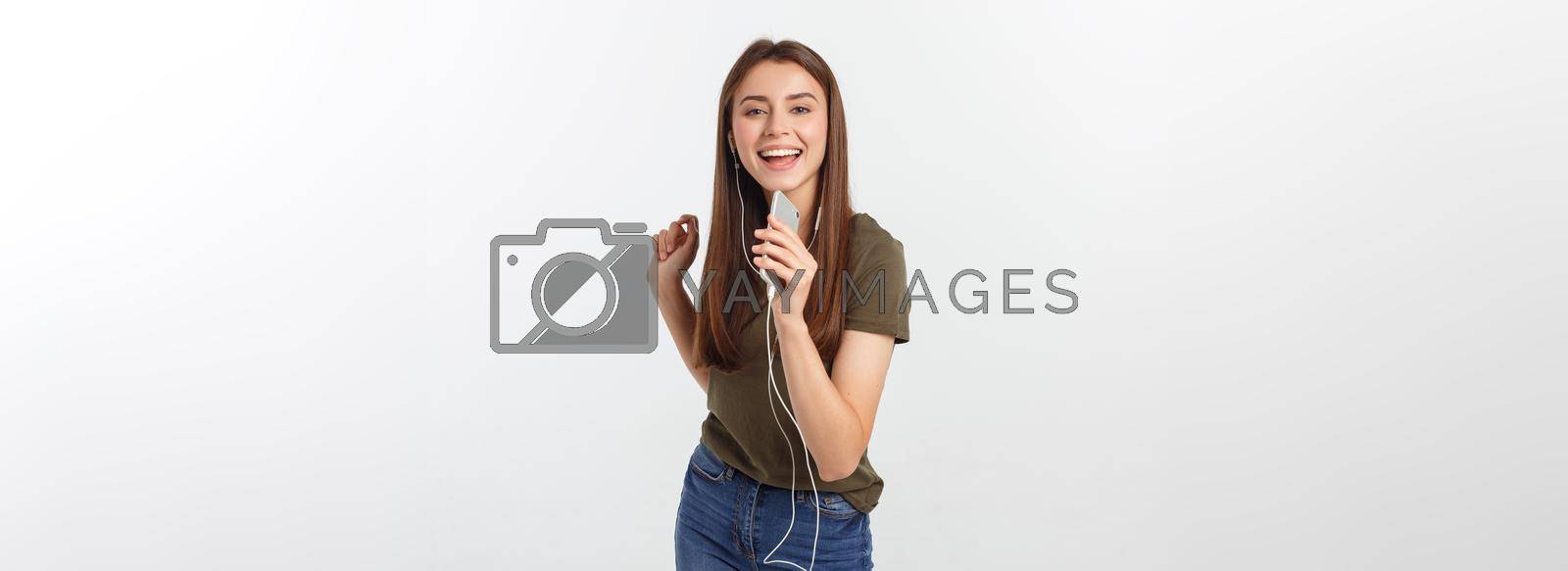 Royalty free image of Portrait of a cheerful cute woman listening music in headphones and dancing isolated on a white background. by Benzoix