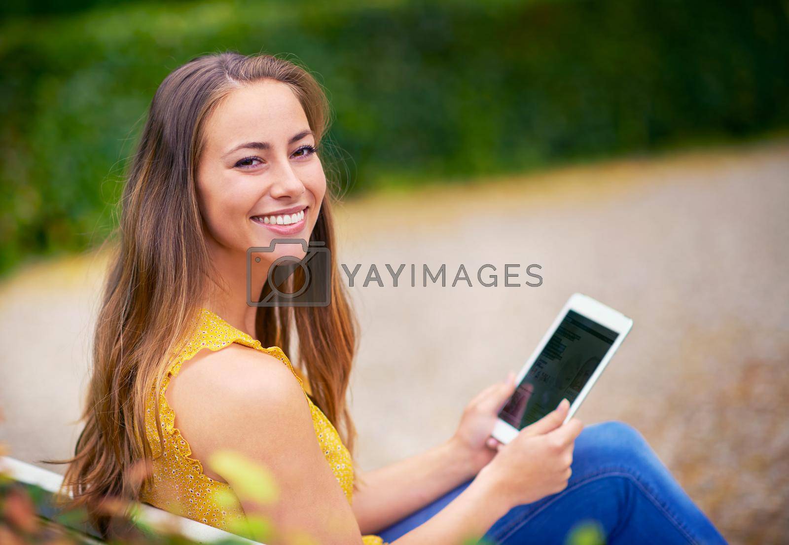 Royalty free image of I took my tablet to the park. a young woman using a digital tablet at the park. by YuriArcurs