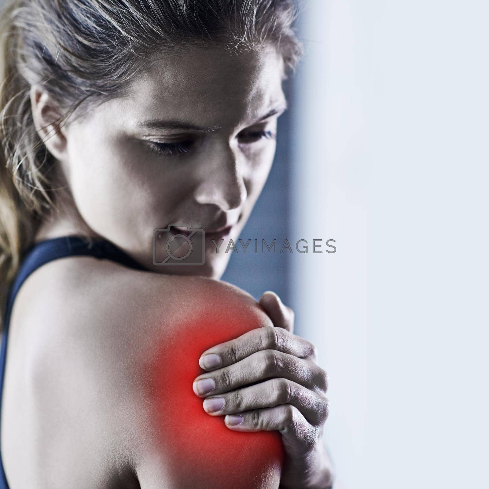 Royalty free image of If it doesnt challenge you, it doesnt change you. a young woman holding her injured shoulder thats highlighted in red. by YuriArcurs