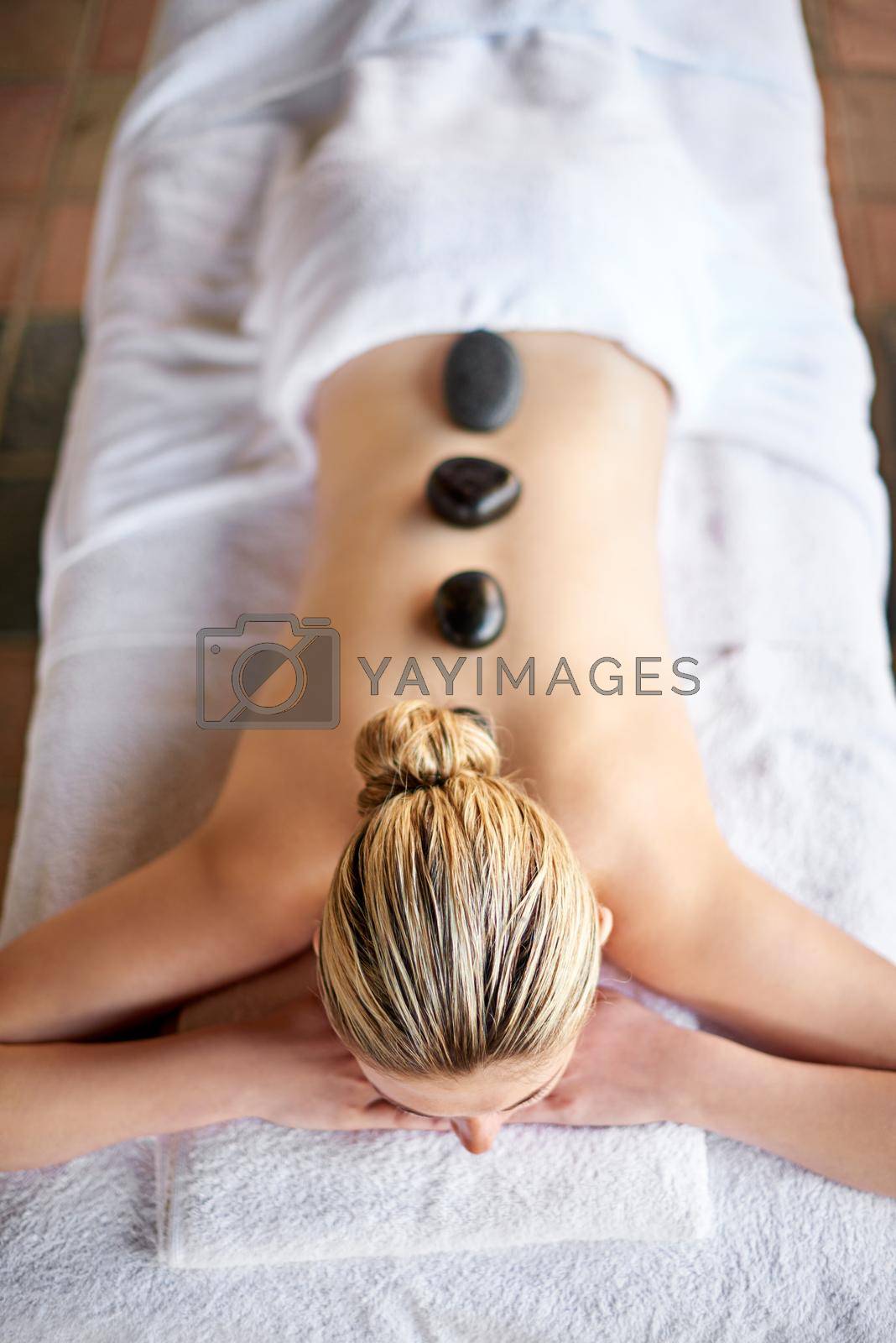 Royalty free image of Spa bliss. a young woman having a lastone treatment at the spa. by YuriArcurs