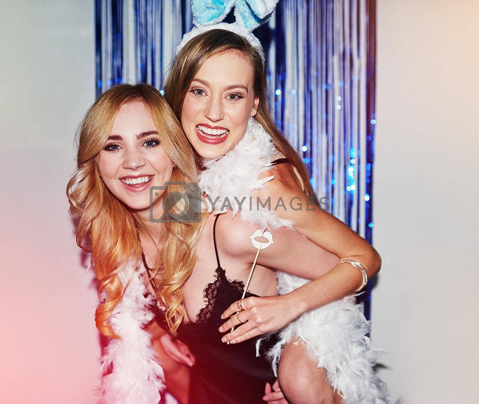 Royalty free image of Fun times with her favourite person. two beautiful young women having fun with props in a photobooth. by YuriArcurs