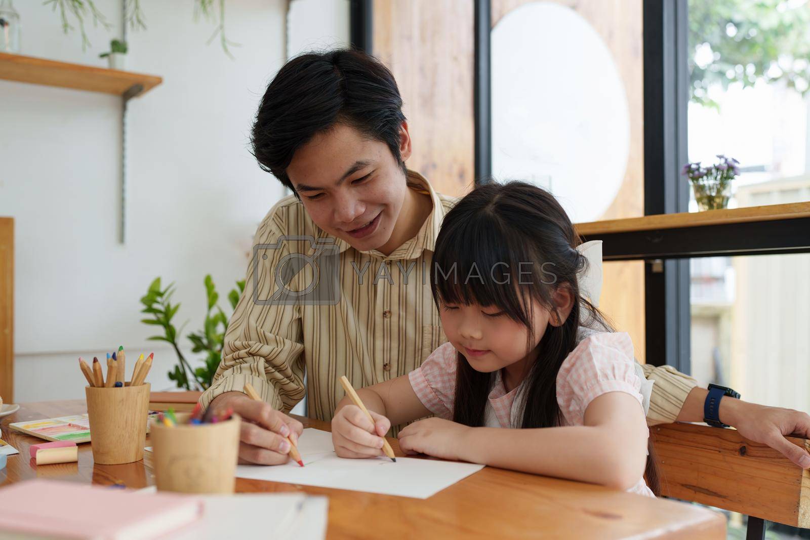 Royalty free image of A happy kid and father painting at home. Handmade skills training by itchaznong