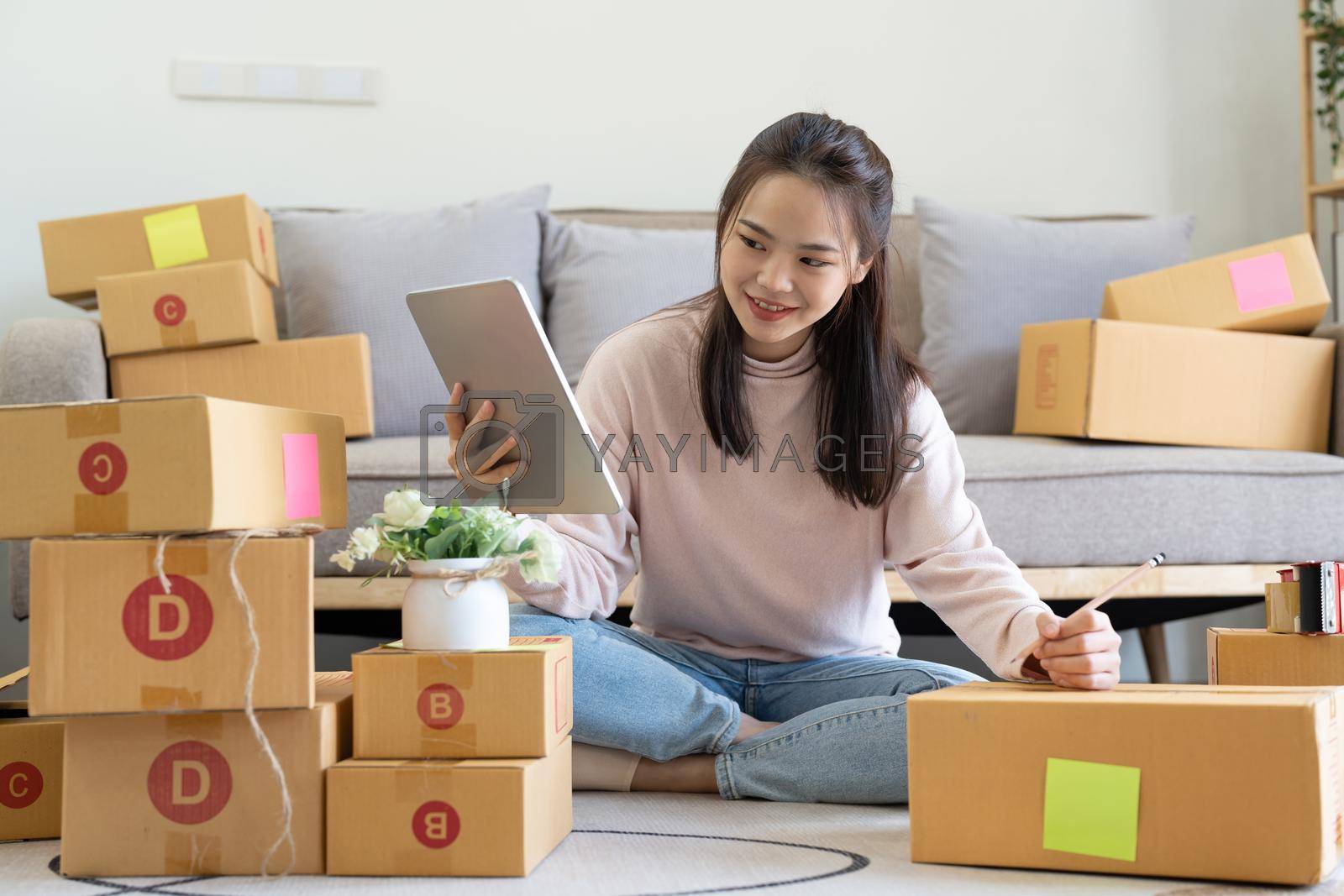 Royalty free image of Female online store small business owner entrepreneur seller packing shipping ecommerce box checking website retail order using laptop preparing delivery parcel. by nateemee