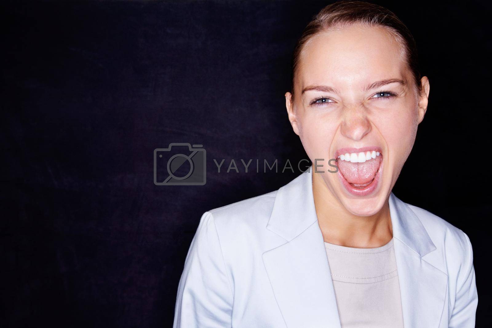 Royalty free image of Aggressive business woman screaming on black background. Young business woman screaming in anger , isolated against black background. by YuriArcurs