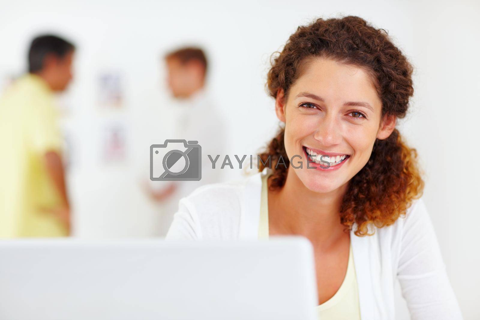 Royalty free image of Attractive business woman using laptop. Closeup portrait of attractive business woman using laptop with colleagues in blurred background. by YuriArcurs