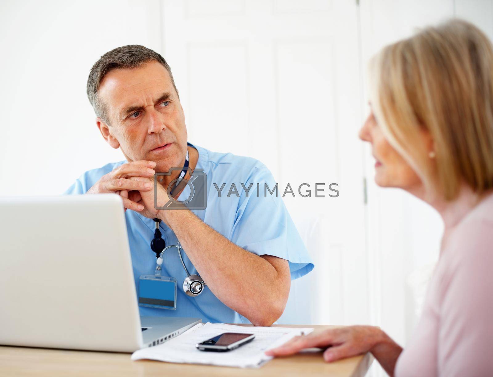 Royalty free image of Medical doctor listening to female patient at clinic. Portrait of a medical doctor listening to female patient at clinic. by YuriArcurs