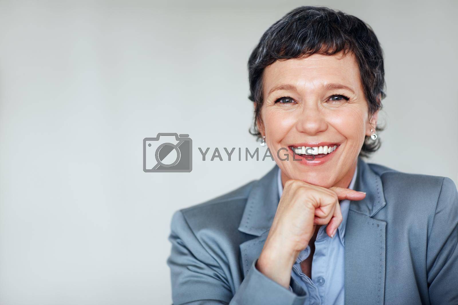 Royalty free image of Mature business woman. Portrait of happy mature business woman smiling over plain background. by YuriArcurs