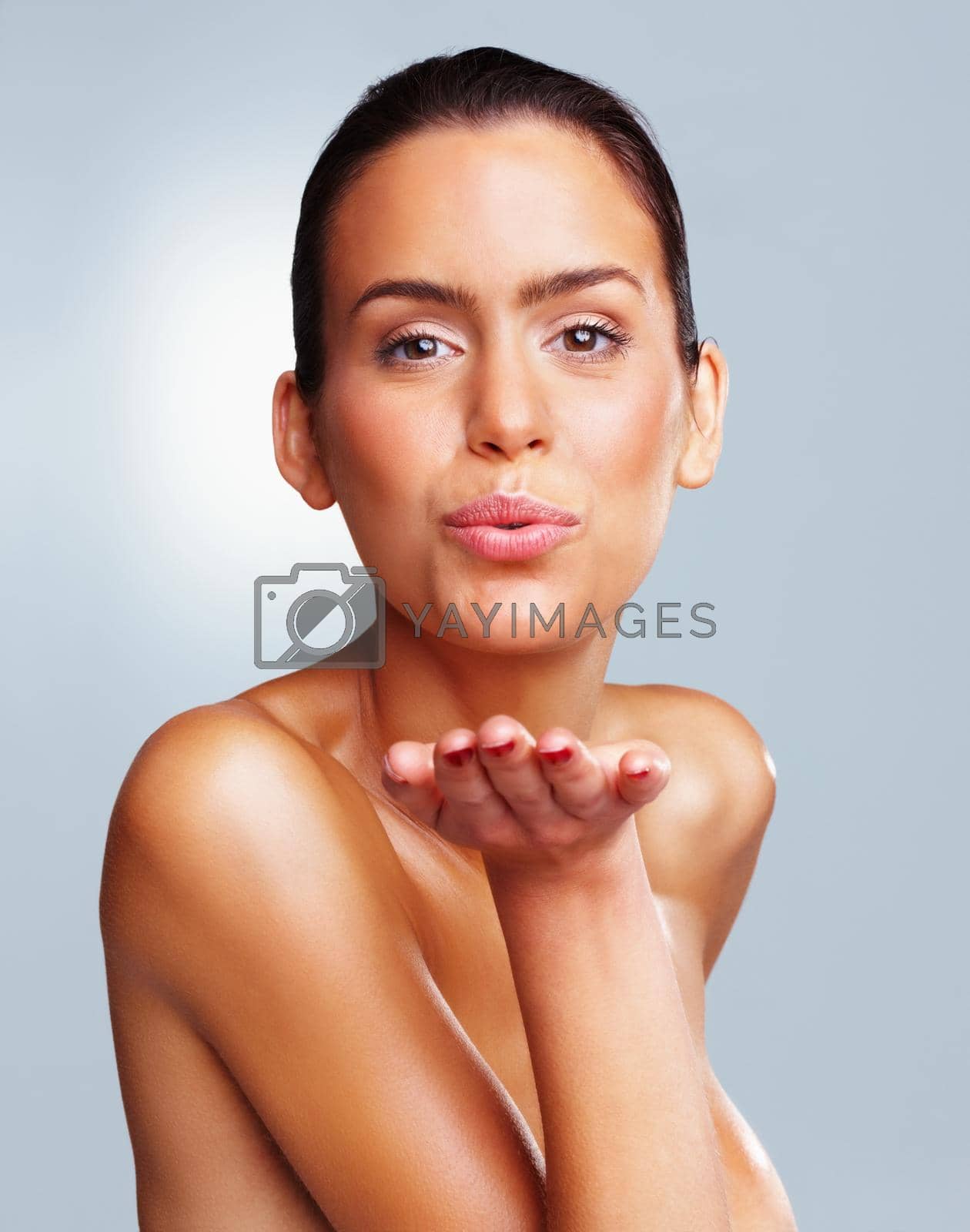Royalty free image of Naked young woman giving you a flying kiss. Portrait of a naked young woman giving you a flying kiss against colored background. by YuriArcurs