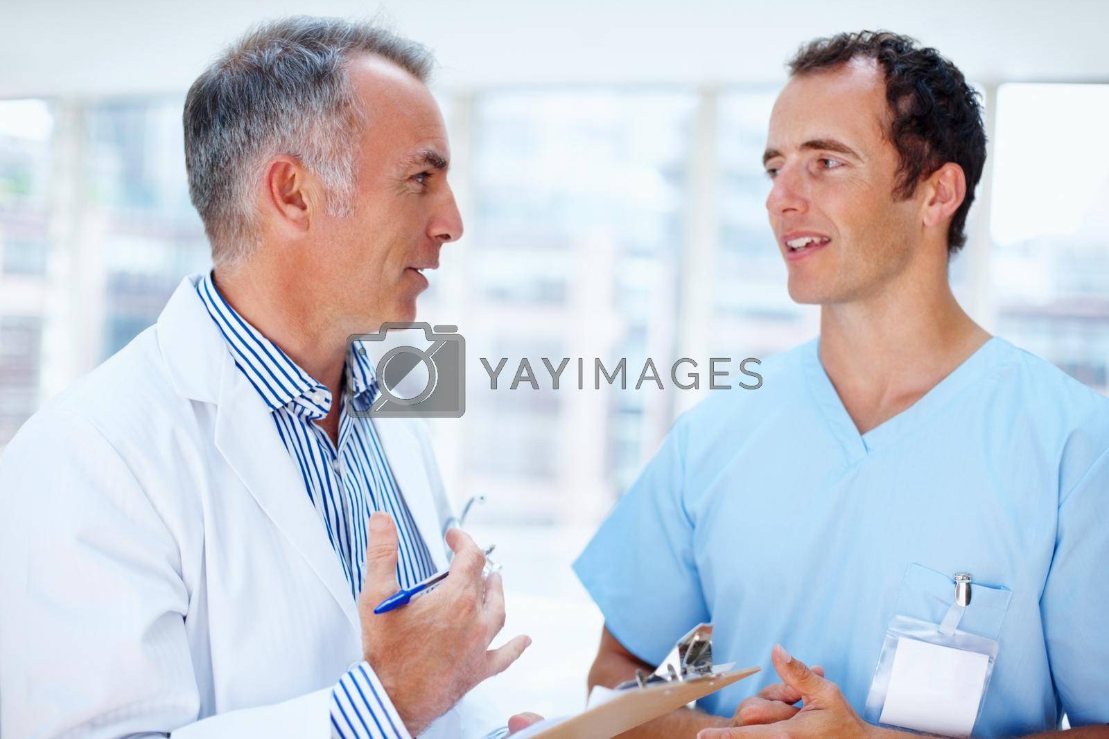 Doctor and resident discussing options. Two men in the healthcare profession having discussion