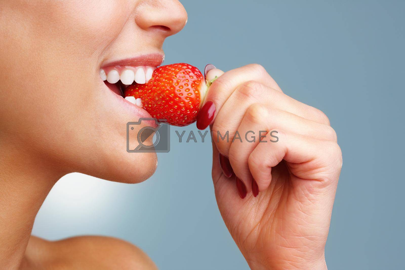 Royalty free image of Macro view of a pretty young female eating fresh strawberry. Macro view of a pretty young woman eating fresh strawberry. by YuriArcurs