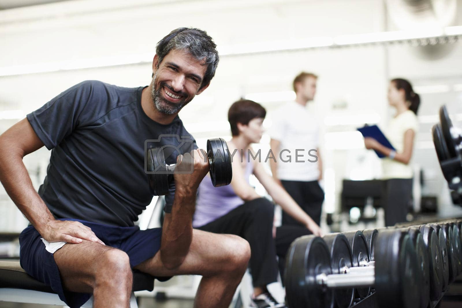 Royalty free image of I love working out. Cropped portrait of a handsome young man working out with weights in the gym. by YuriArcurs