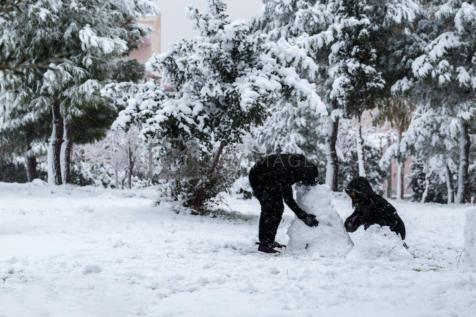 Couple making a snow man, unusual weather in Athens, Greece