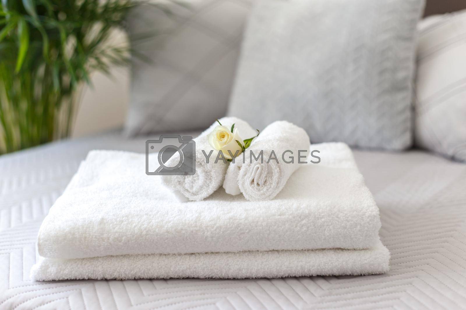 Royalty free image of Rolled white towels on the bed in the hotel room by Lana_M