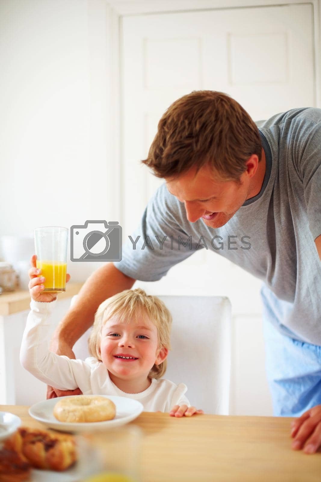 Royalty free image of Happy little boy with his father holding glass of juice. Portrait of a happy little boy with his father holding glass of juice. by YuriArcurs