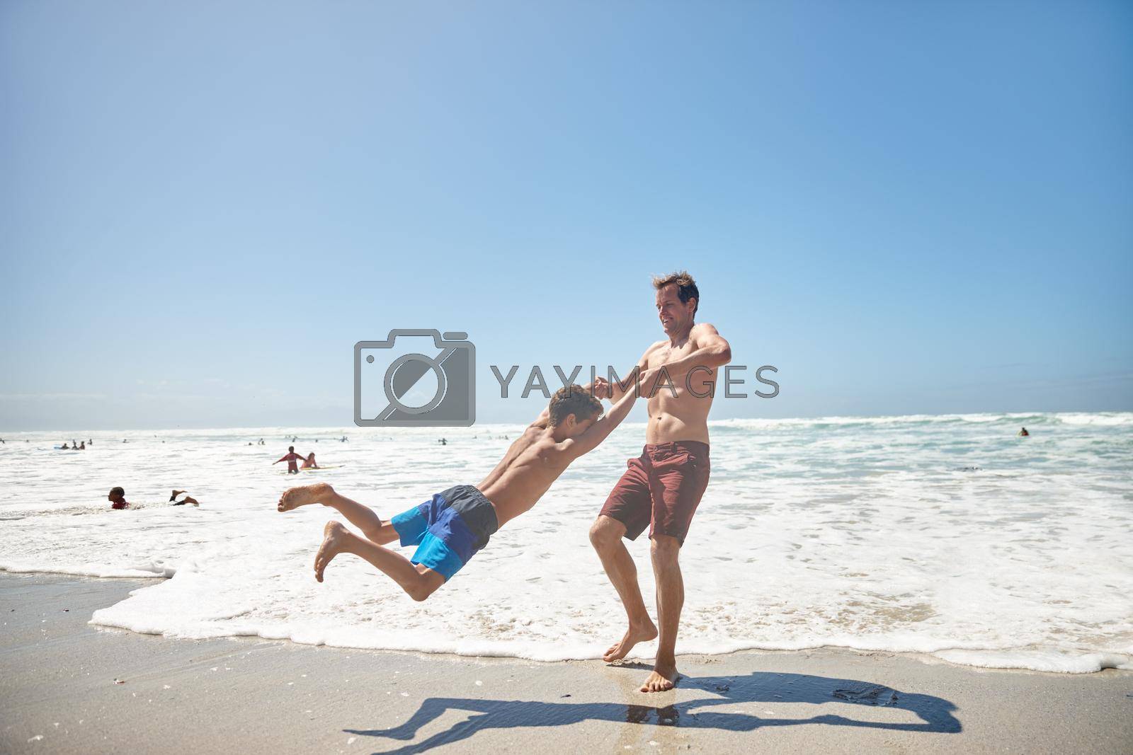 Royalty free image of Hanging out with his dad. a father and his son having fun at the beach. by YuriArcurs