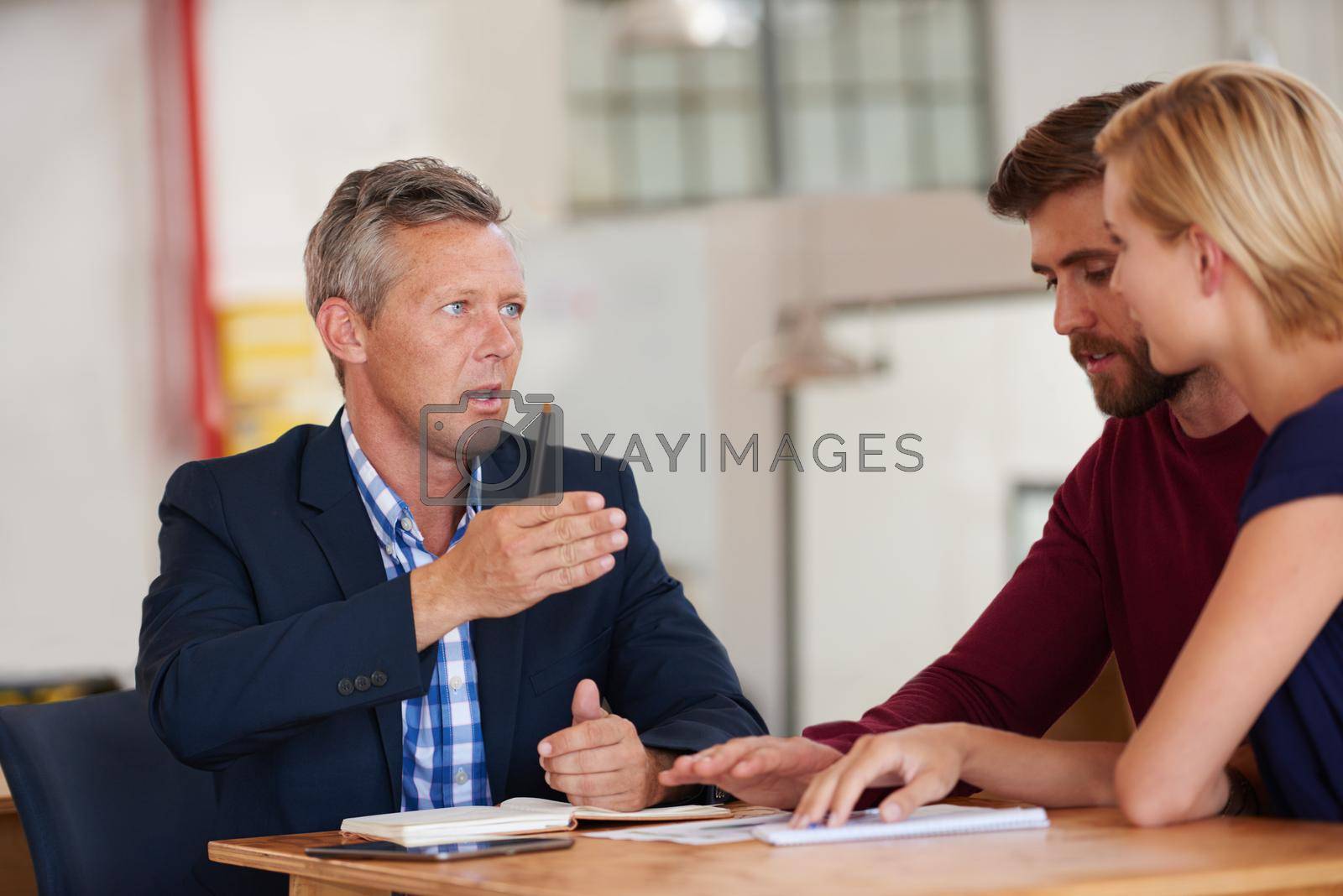 Royalty free image of Giving them professional advice on asset management. Young couple discussing investment plans with a financial advisor. by YuriArcurs