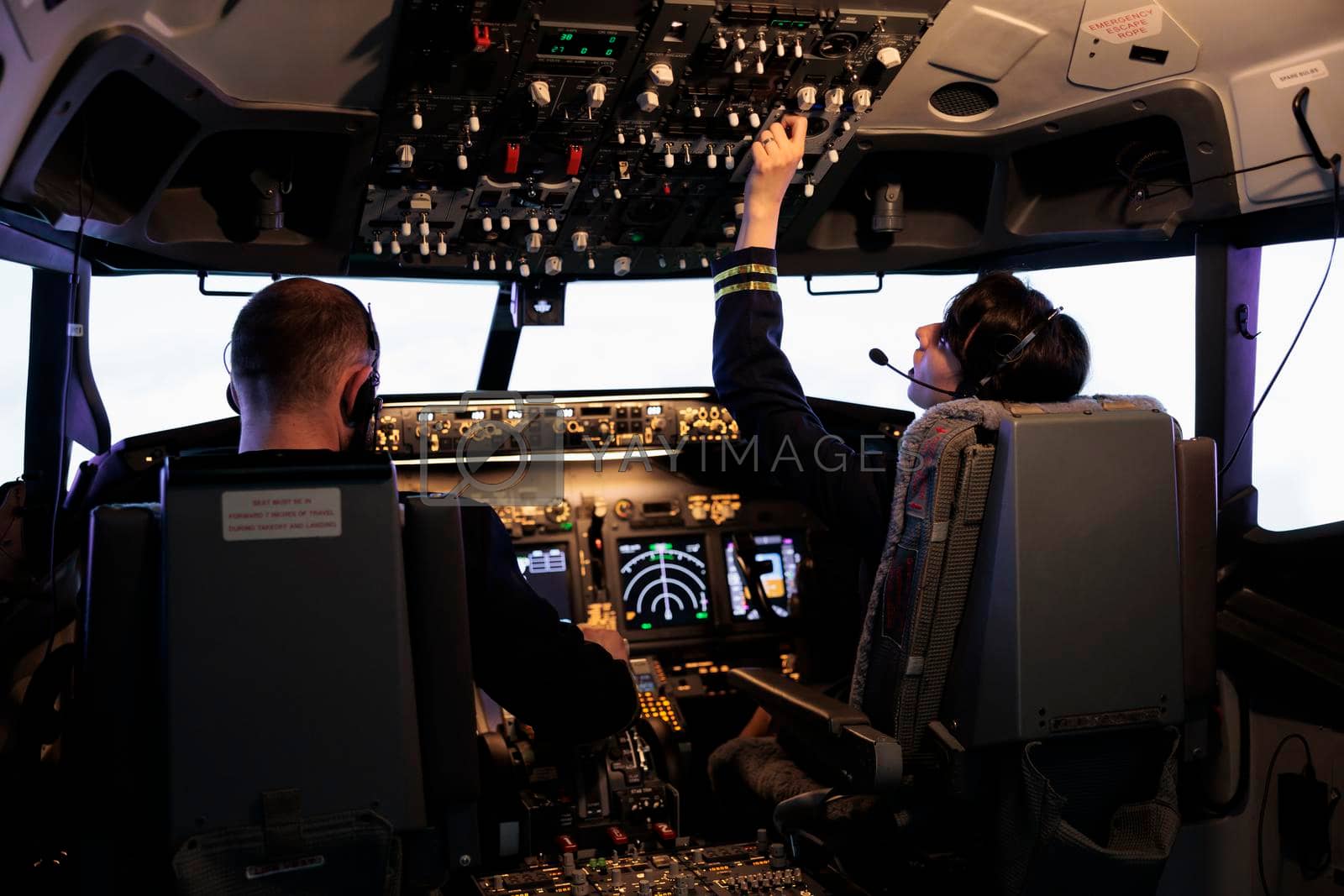 Royalty free image of Aircrew members flying airplane with dashboard command by DCStudio