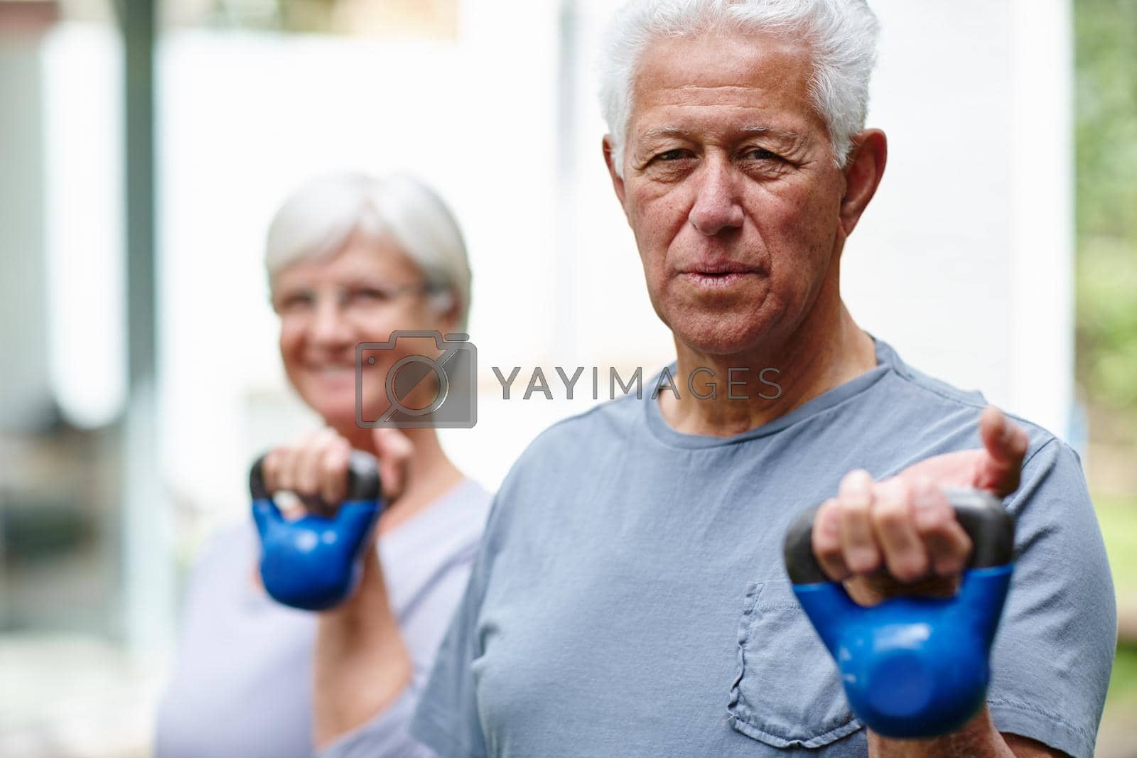 Royalty free image of Strength training for seniors. a senior couple training with light weights outdoors. by YuriArcurs