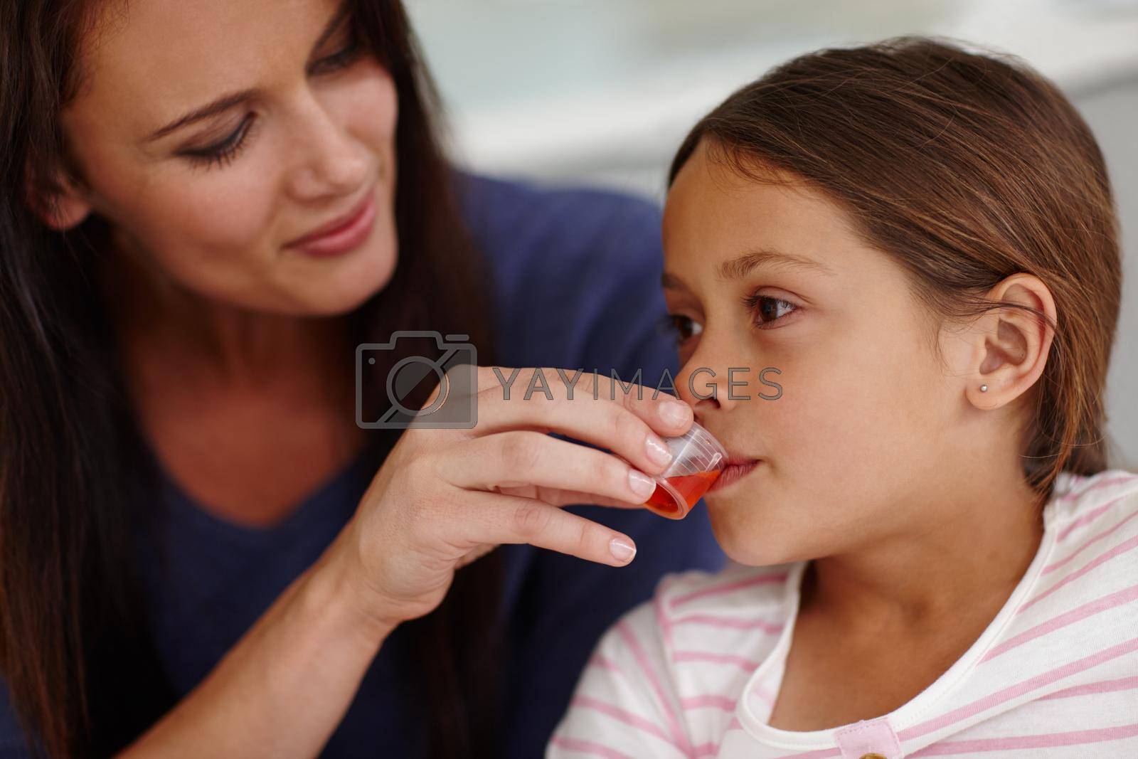 Royalty free image of Mom knows best. a caring mother giving her sick little girl some medicine. by YuriArcurs