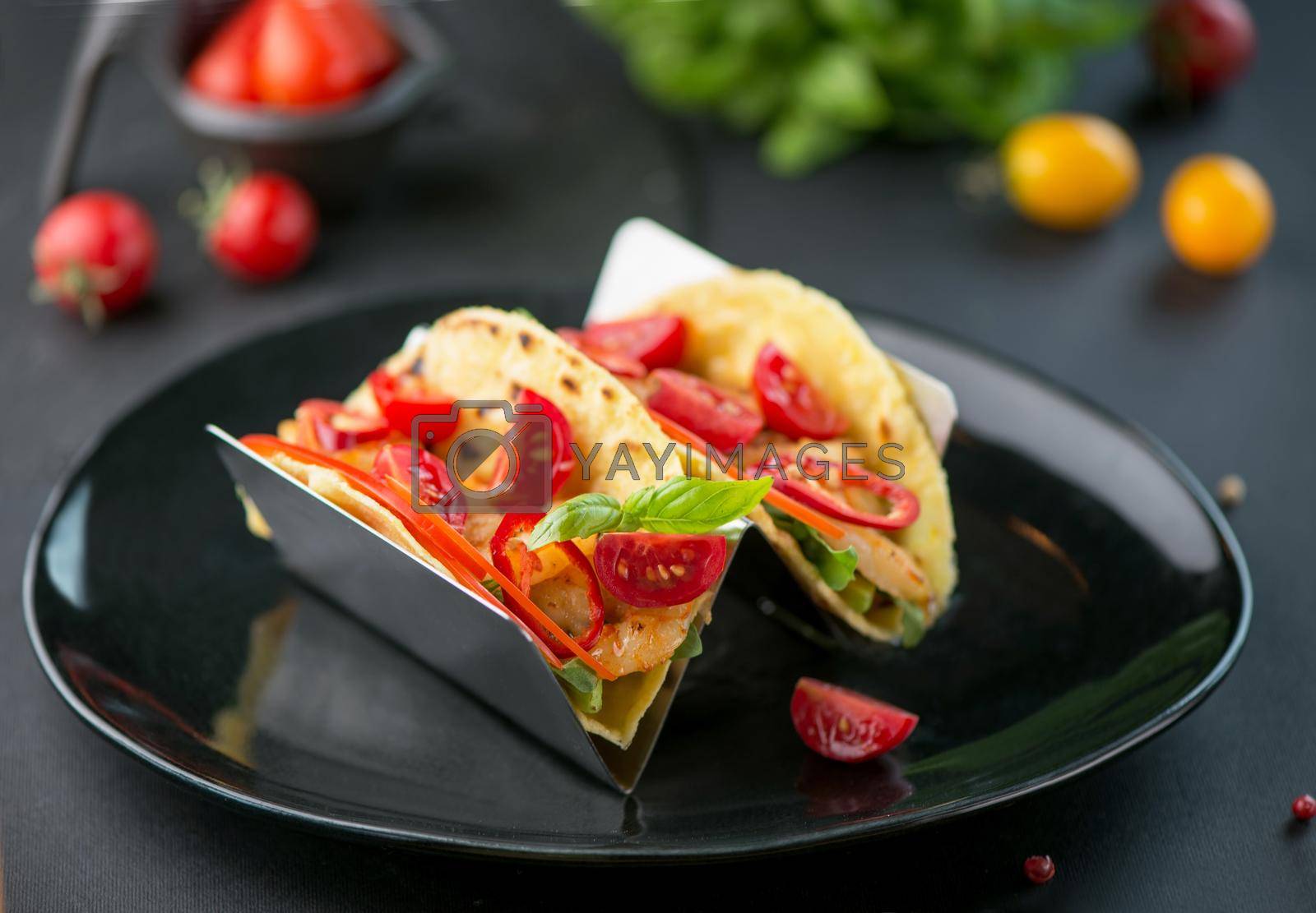 Royalty free image of mexican food. Spicy tacos with tomatoes and meat on a dark background by aprilphoto