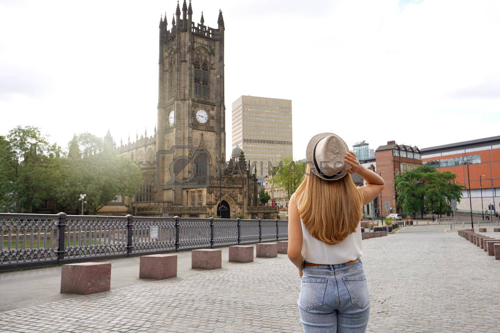 Royalty free image of Back view of beautiful blonde girl with hat walking in Manchester city on sunny day, England, United Kingdom by sergio_monti