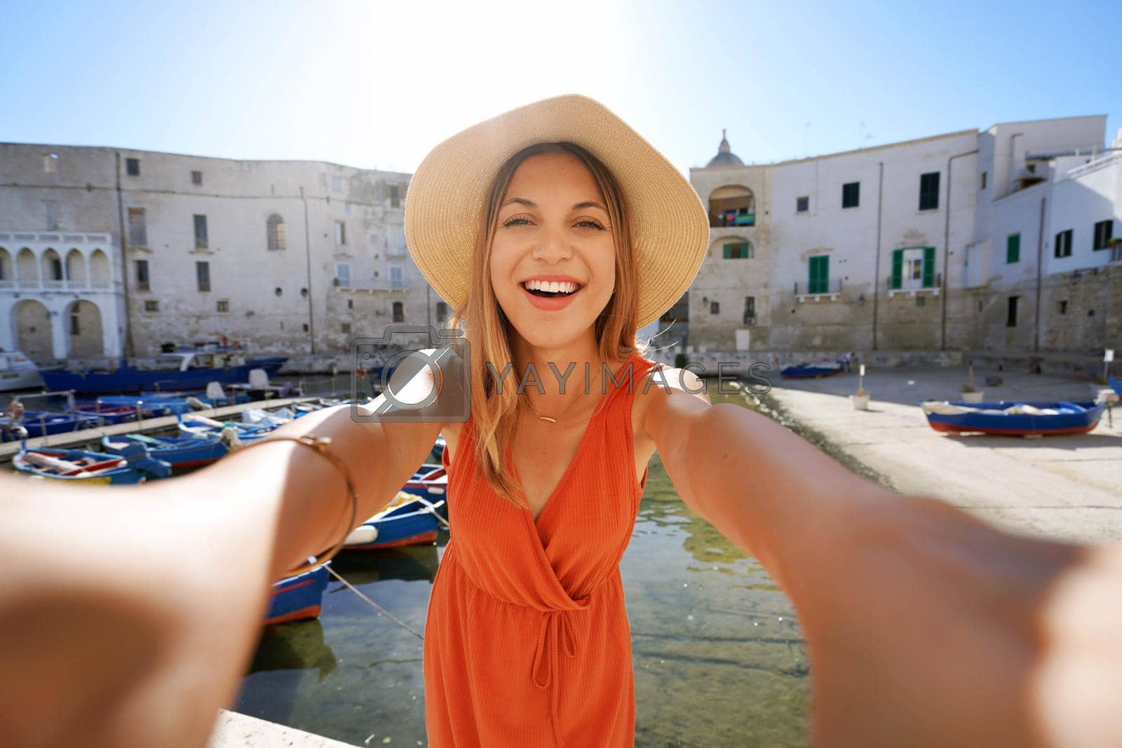 Royalty free image of Selfie girl in southern Italy. Young tourist woman taking self portrait with the ancient port of Monopoli, Apulia, Italy. by sergio_monti
