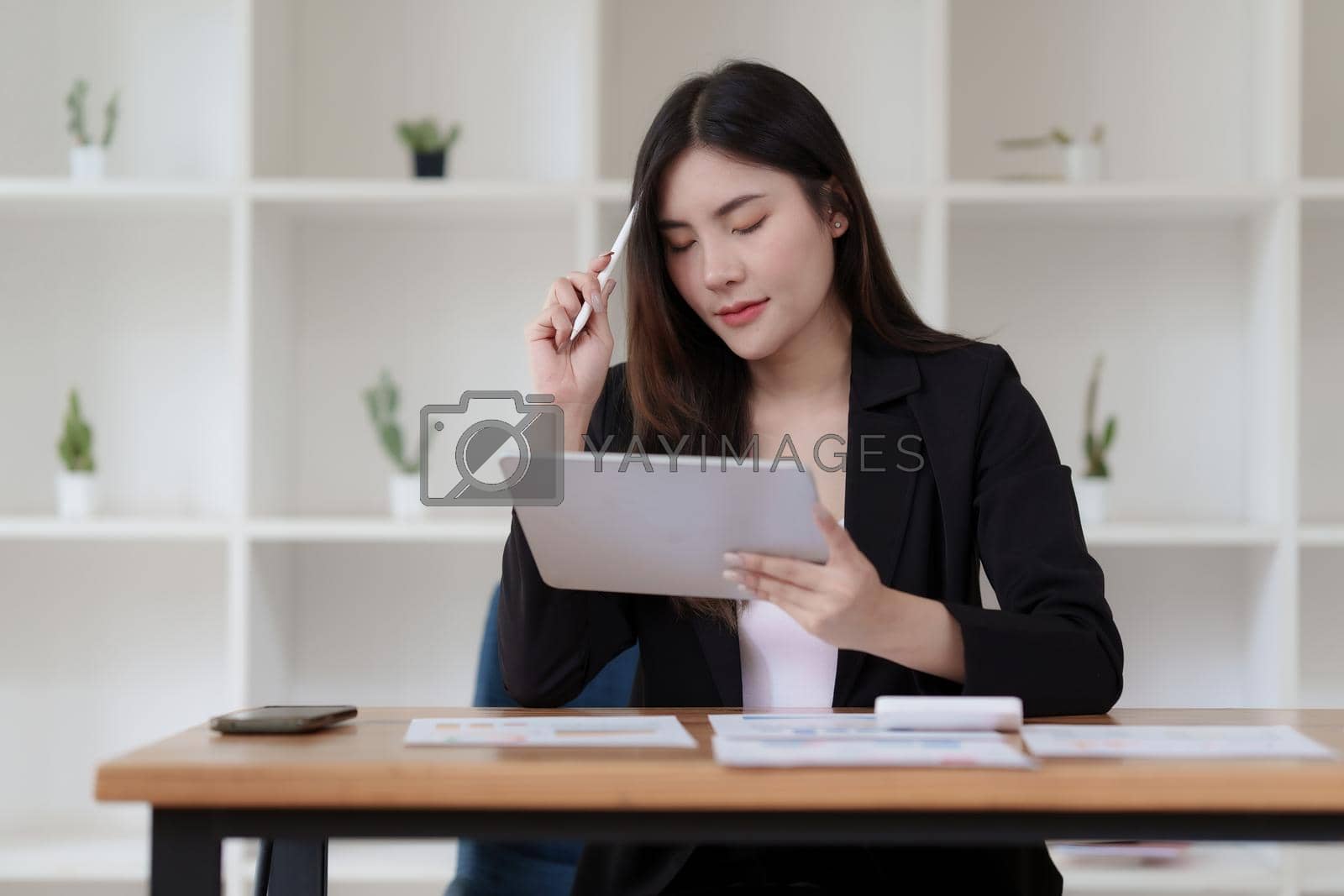 Royalty free image of Accountant checking data document on digital tablet for investigation of corruption account by itchaznong