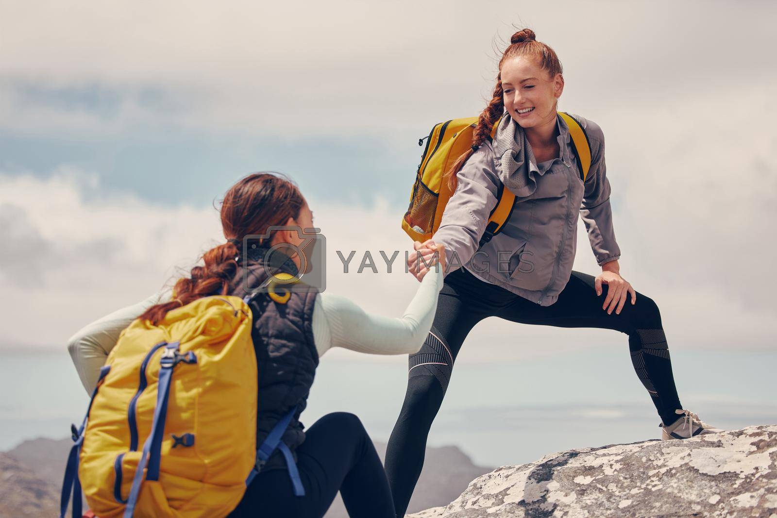 Royalty free image of Help hands, friends or women hiking up a mountain, hill or in nature with a smile. Travel, adventure and trekking females on an outdoor, countryside or rock climbing recreation exercise activity. by YuriArcurs