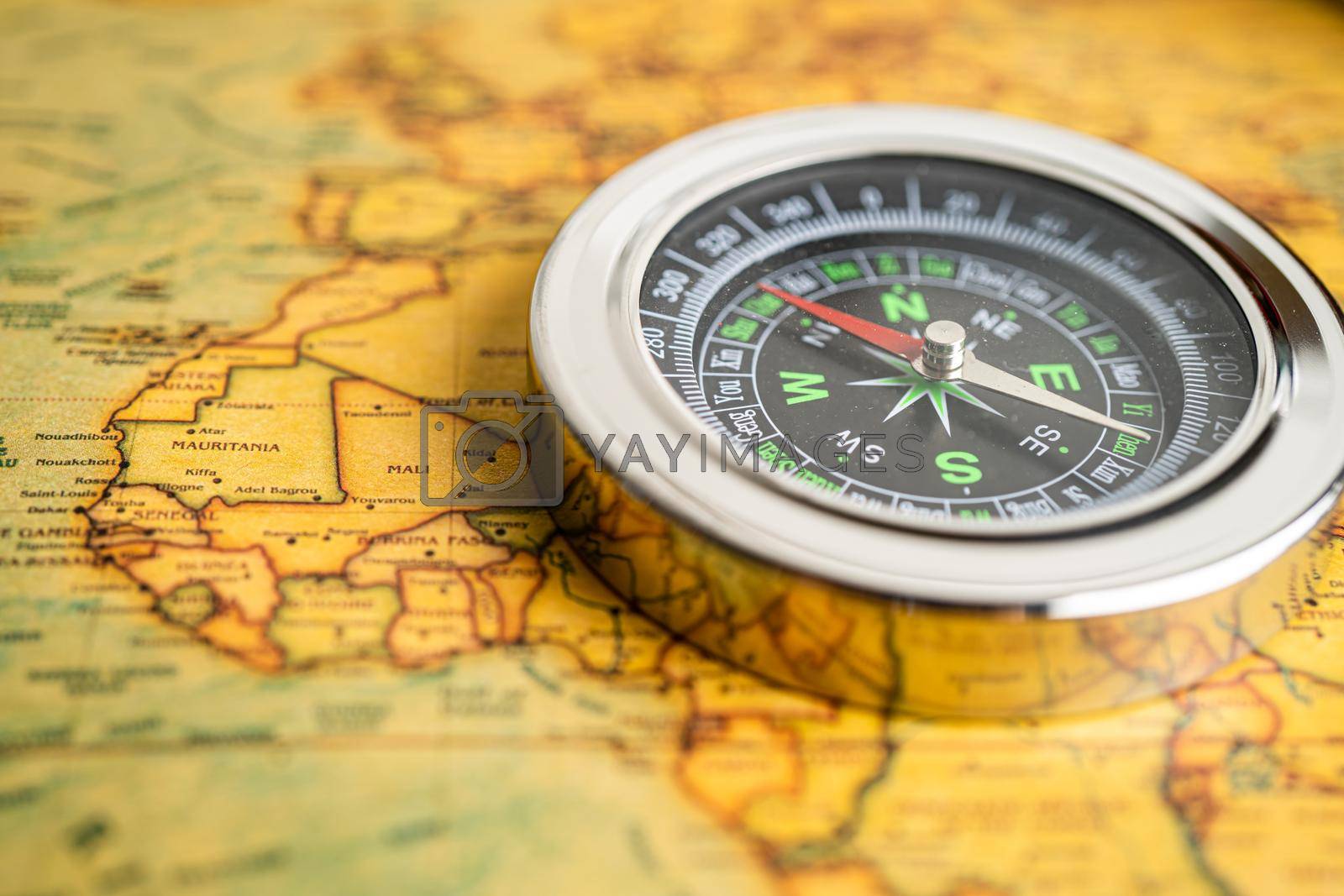 Bangkok, Thailand - January 20, 2022 Compass for navigation on vintage old antique world map background to travel, geography, tourism and exploration concept.