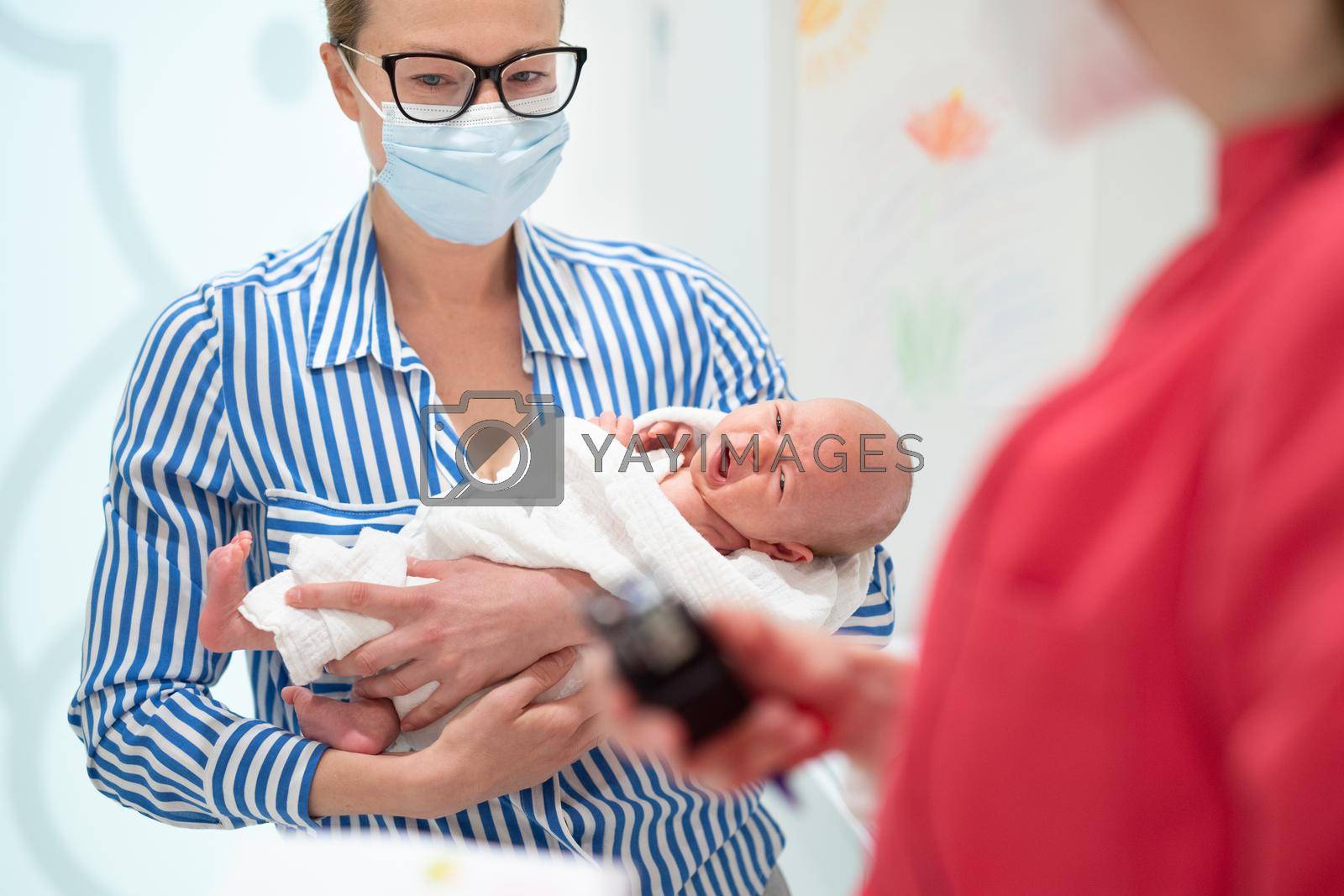 Royalty free image of Mother holding her baby boy at medical appointment at pediatrician office. by kasto
