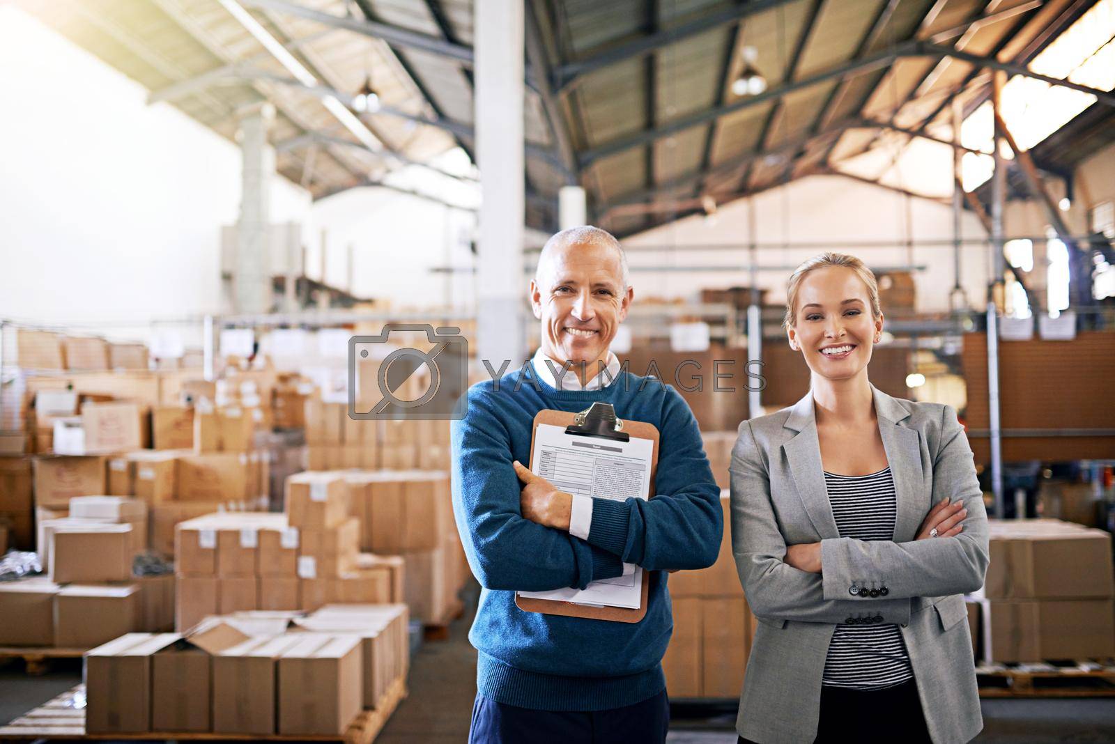 Royalty free image of Shipping is our business and business is good. Portrait of two mangers standing in a large warehouse. by YuriArcurs