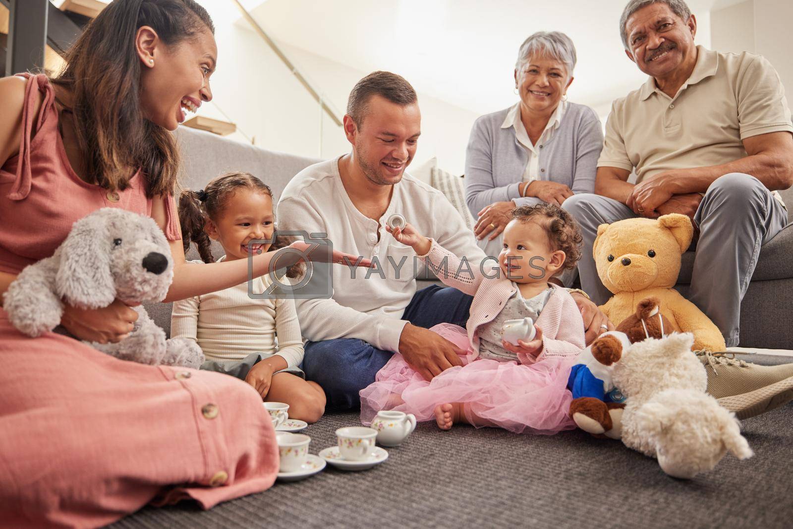 Royalty free image of Big family portrait in kids room with tea party toys for play and bonding together on the floor. Happy grandparents, mother and father with baby in their family home having fun sitting on the ground by YuriArcurs