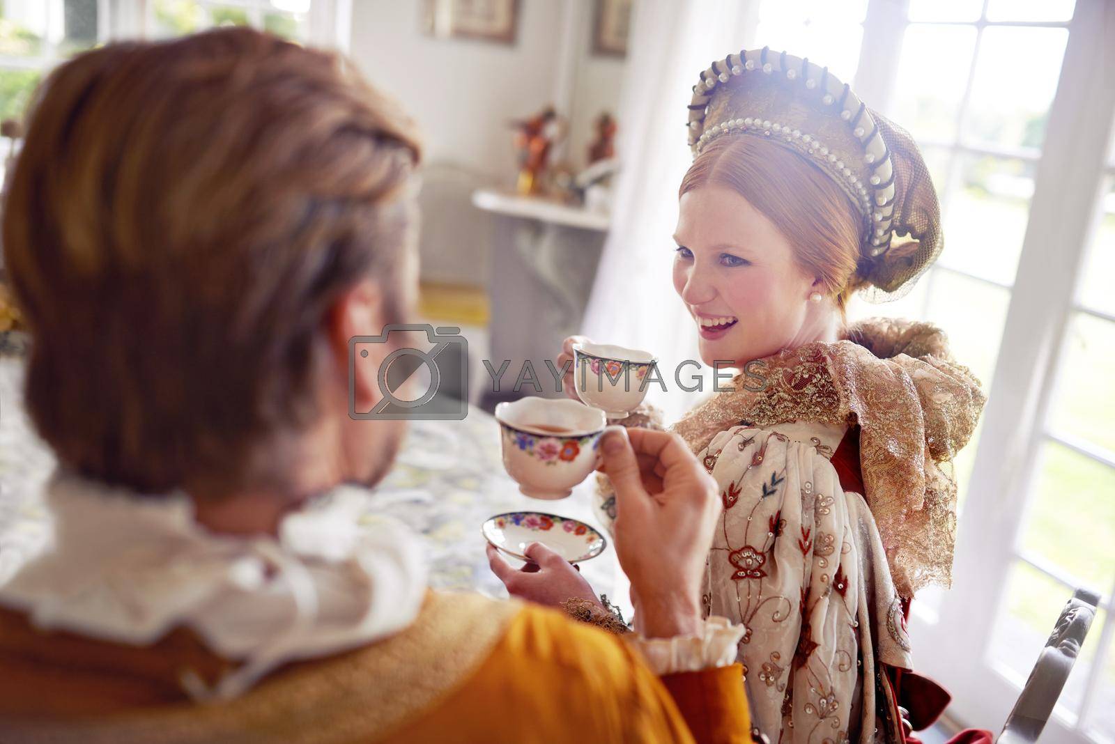 Royalty free image of Living the royal life. A king and queen taking tea together at home. by YuriArcurs