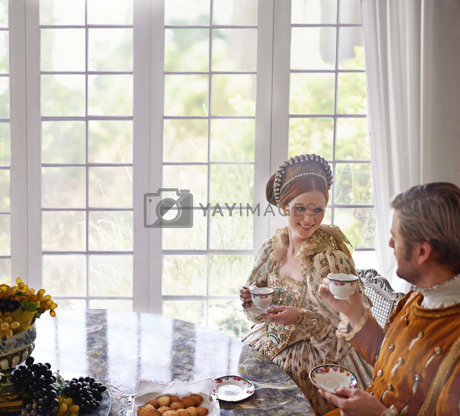 Royalty free image of Ah tea...the mark of the civilized. A king and queen taking tea together at home. by YuriArcurs