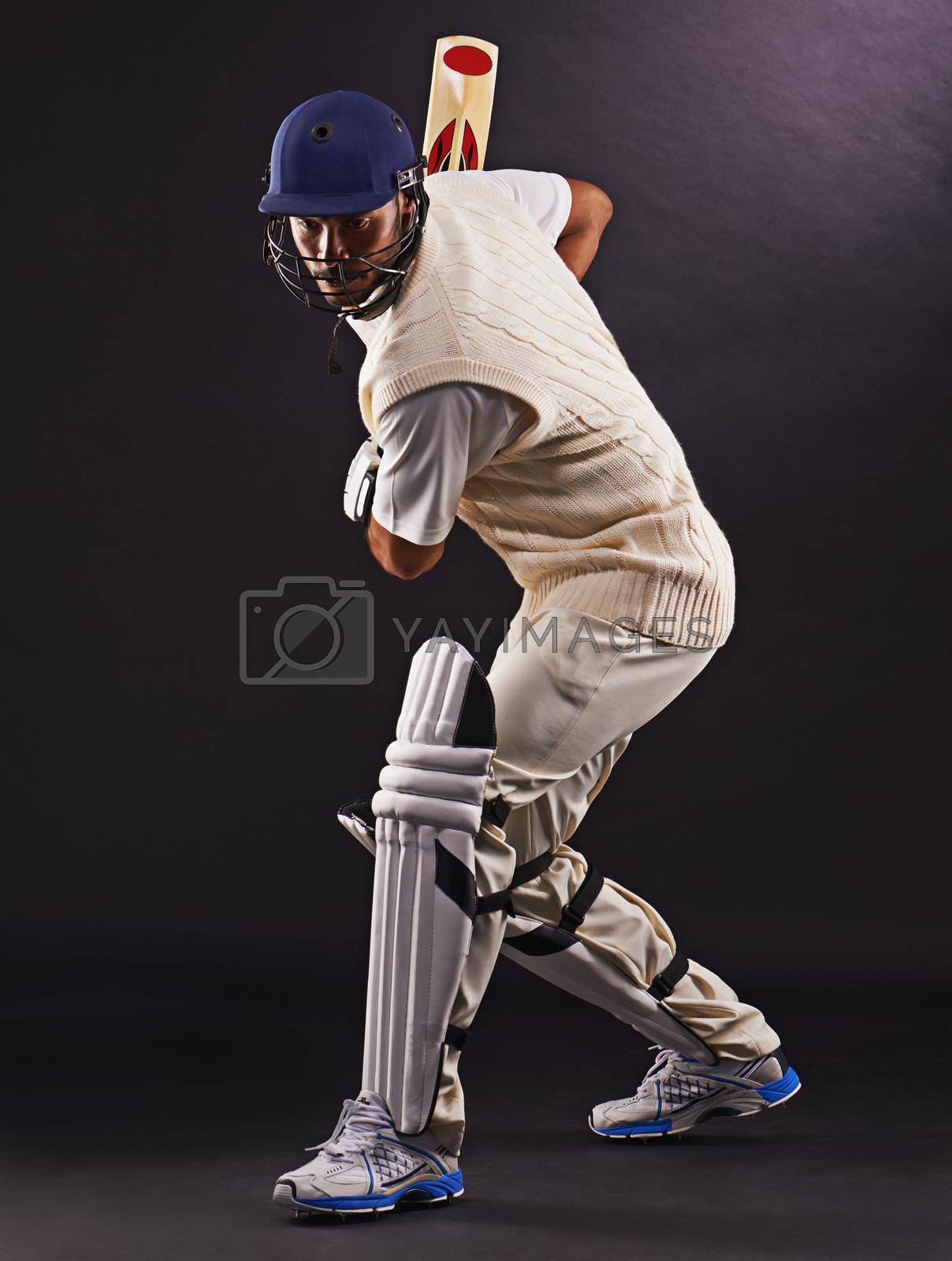 Royalty free image of The perfect strike. A cropped shot of an ethnic young man in cricket attire isolated on black. by YuriArcurs