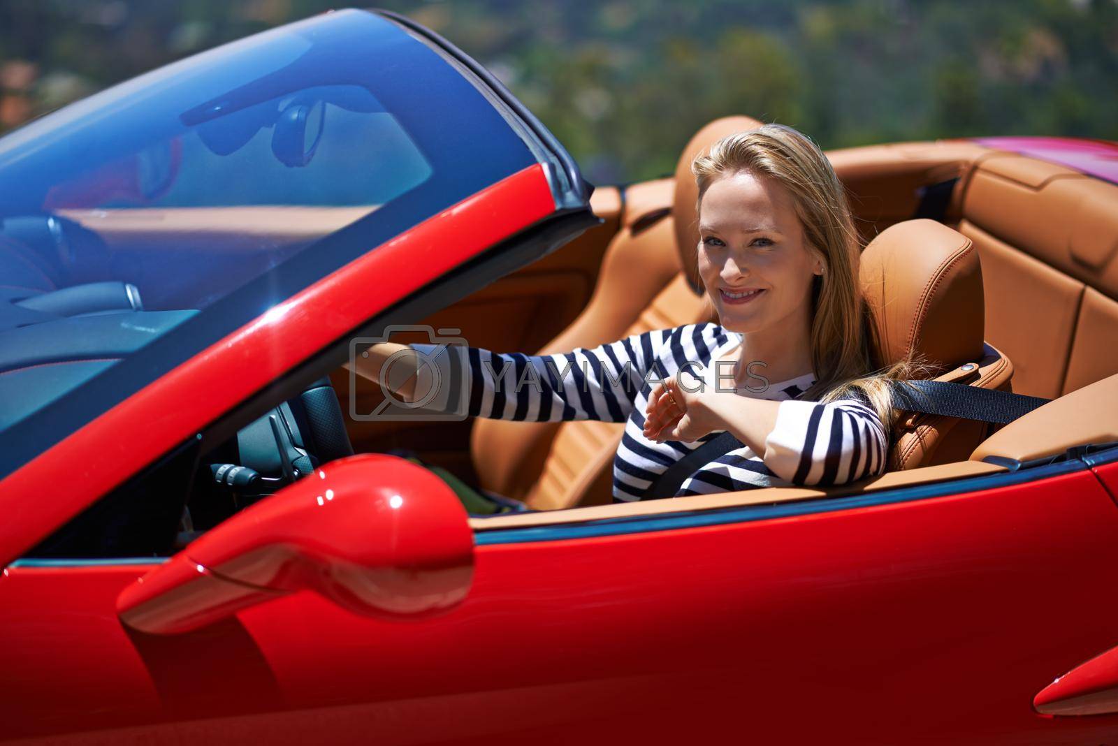 Royalty free image of This car is built to go. a young woman driving in a sports car. by YuriArcurs
